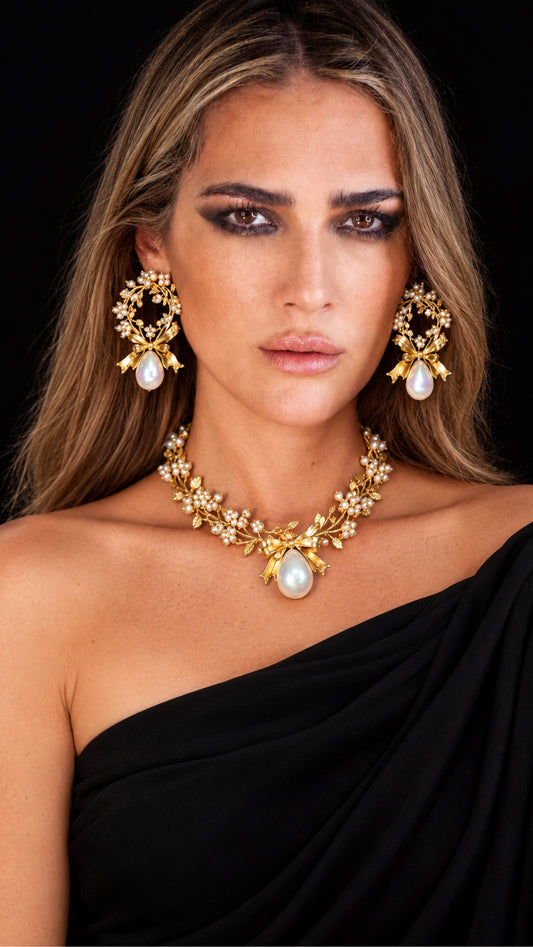 Model wearing handmade gold-plated brass pearl bow earrings and necklace set