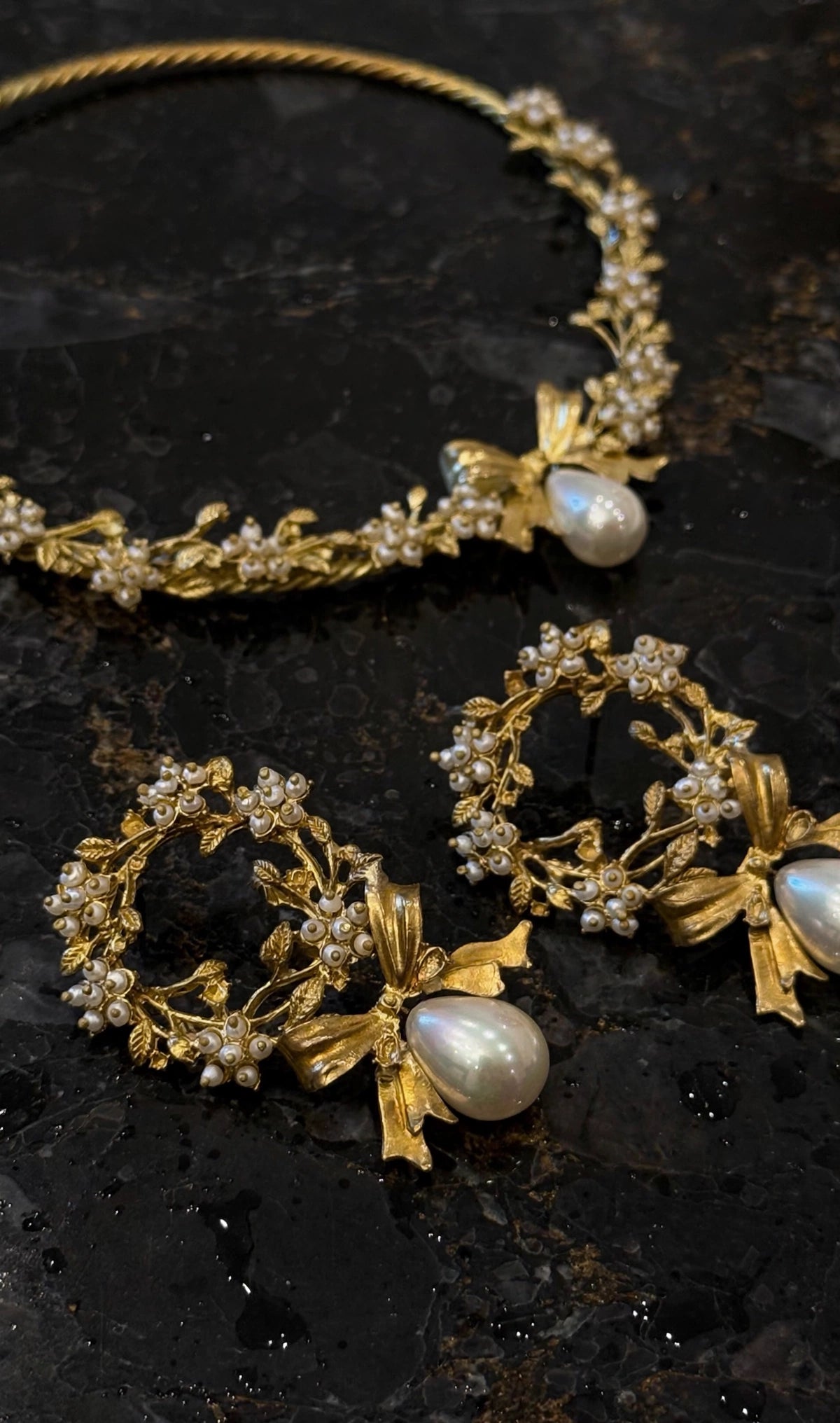 Gold-plated brass pearl bow necklace collar and wreath earrings on black marble